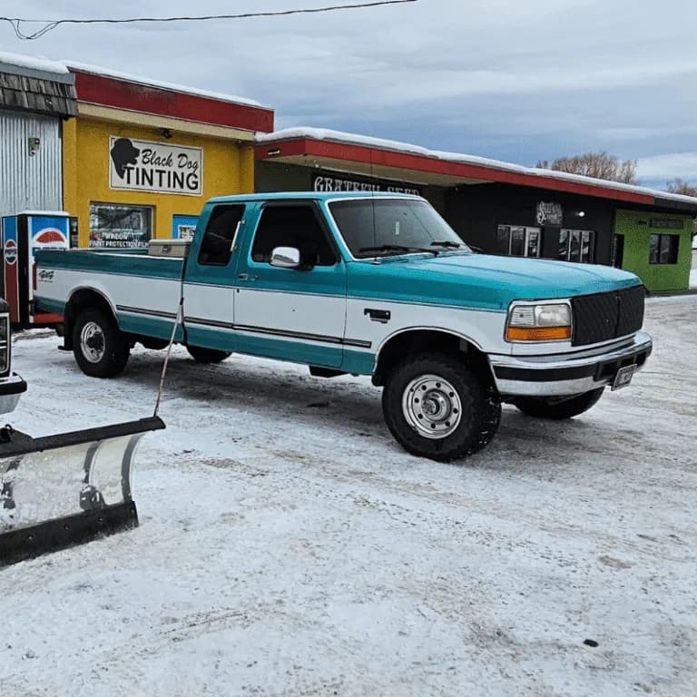 Teal classic pickup outside Black Dog Tinting