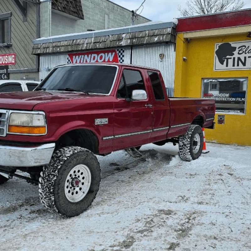 Red classic pickup outside Black Dog Tinting
